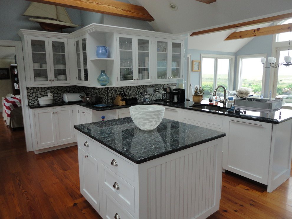 Inspiration for a mid-sized coastal u-shaped medium tone wood floor eat-in kitchen remodel in Boston with a single-bowl sink, glass-front cabinets, white cabinets, granite countertops, blue backsplash, mosaic tile backsplash, paneled appliances and an island