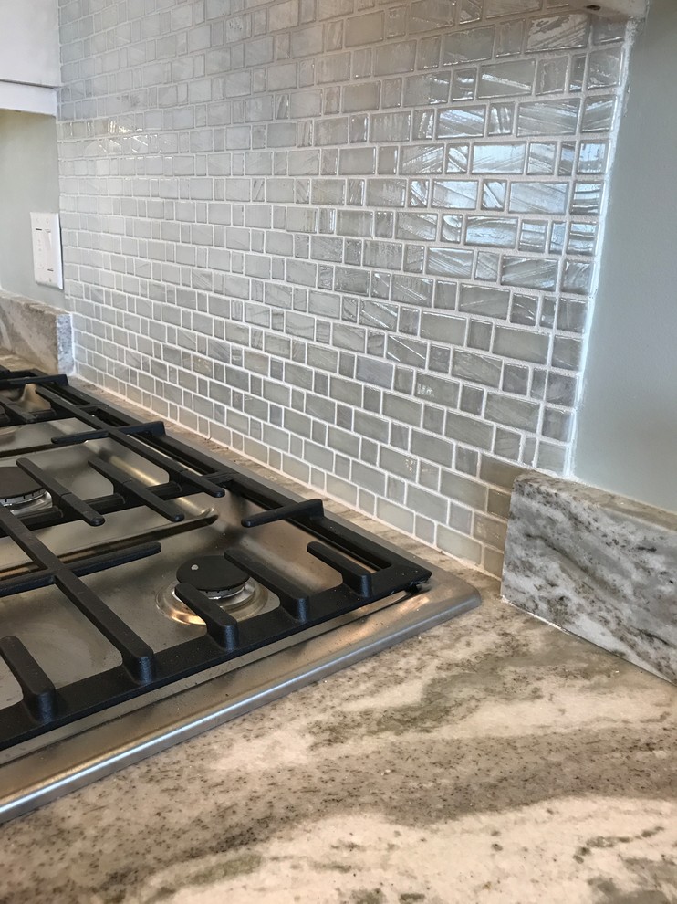 Kitchen pantry - small modern single-wall kitchen pantry idea in New York with white cabinets, quartz countertops, metallic backsplash, glass tile backsplash and stainless steel appliances