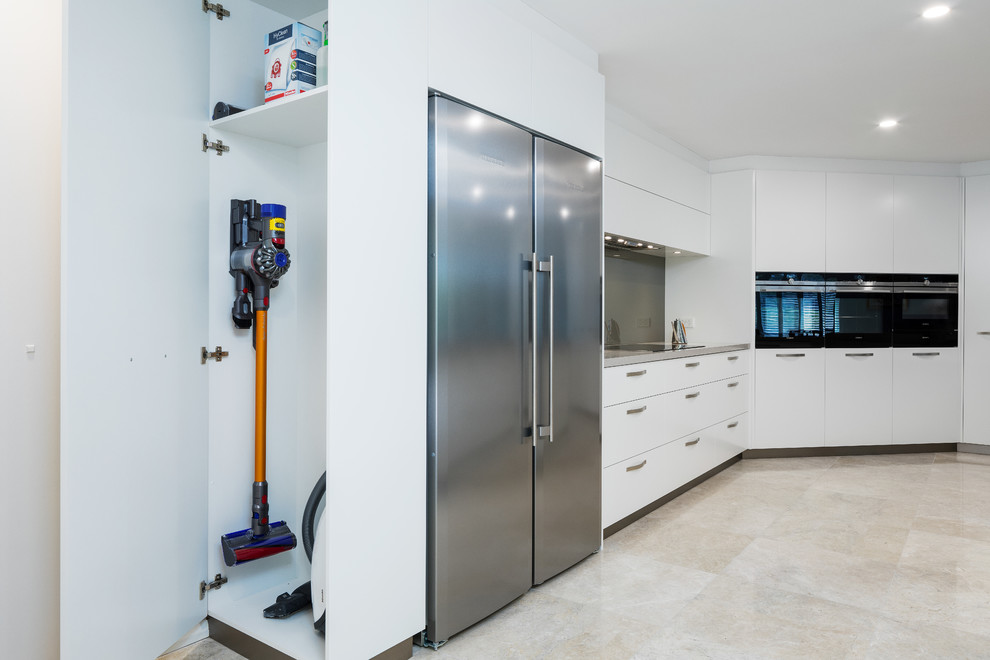 Exemple d'une cuisine moderne avec un placard à porte plane, des portes de placard blanches, un plan de travail en quartz modifié et un plan de travail gris.