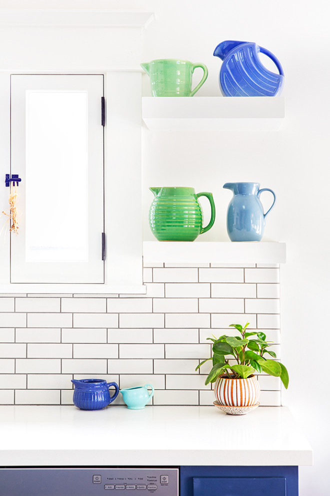 Inspiration for a mid-sized craftsman l-shaped dark wood floor and brown floor enclosed kitchen remodel in Los Angeles with a farmhouse sink, shaker cabinets, blue cabinets, quartz countertops, white backsplash, ceramic backsplash, stainless steel appliances, an island and white countertops