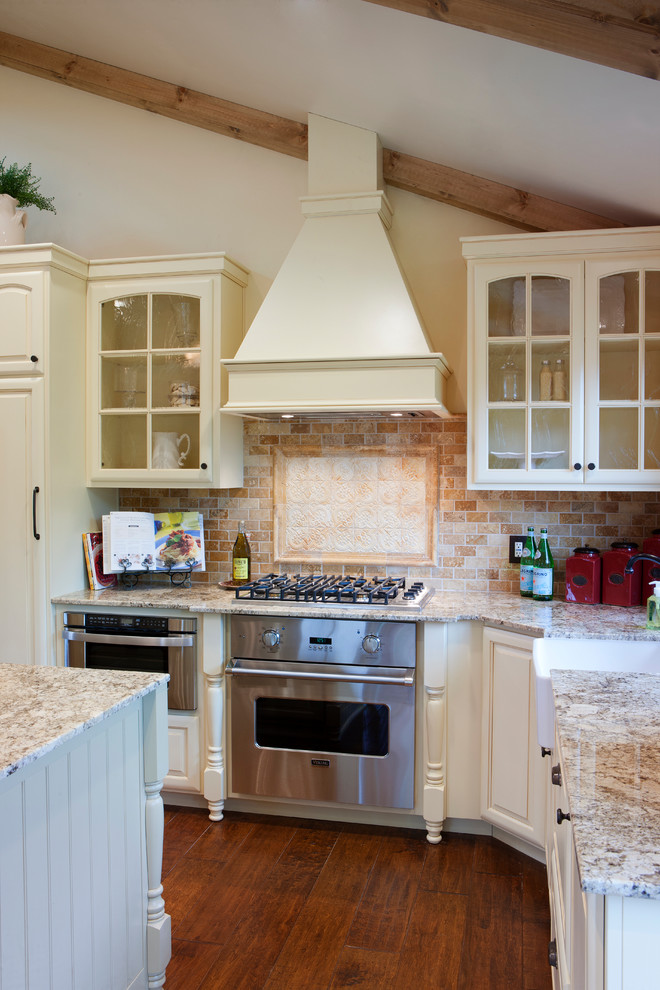 Inspiration för små lantliga kök, med en rustik diskho, luckor med upphöjd panel, vita skåp, granitbänkskiva, flerfärgad stänkskydd, stänkskydd i stenkakel, integrerade vitvaror, mellanmörkt trägolv och en halv köksö