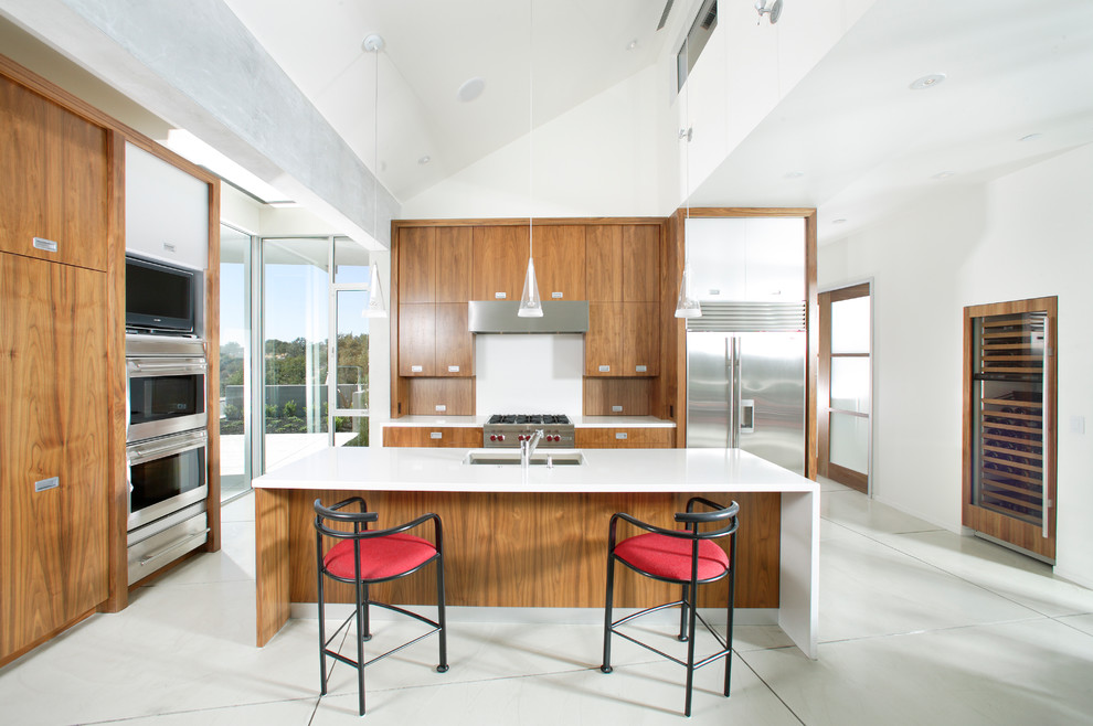 Enclosed kitchen - modern l-shaped marble floor enclosed kitchen idea in Sacramento with an undermount sink, flat-panel cabinets, medium tone wood cabinets, marble countertops, white backsplash, stainless steel appliances and an island