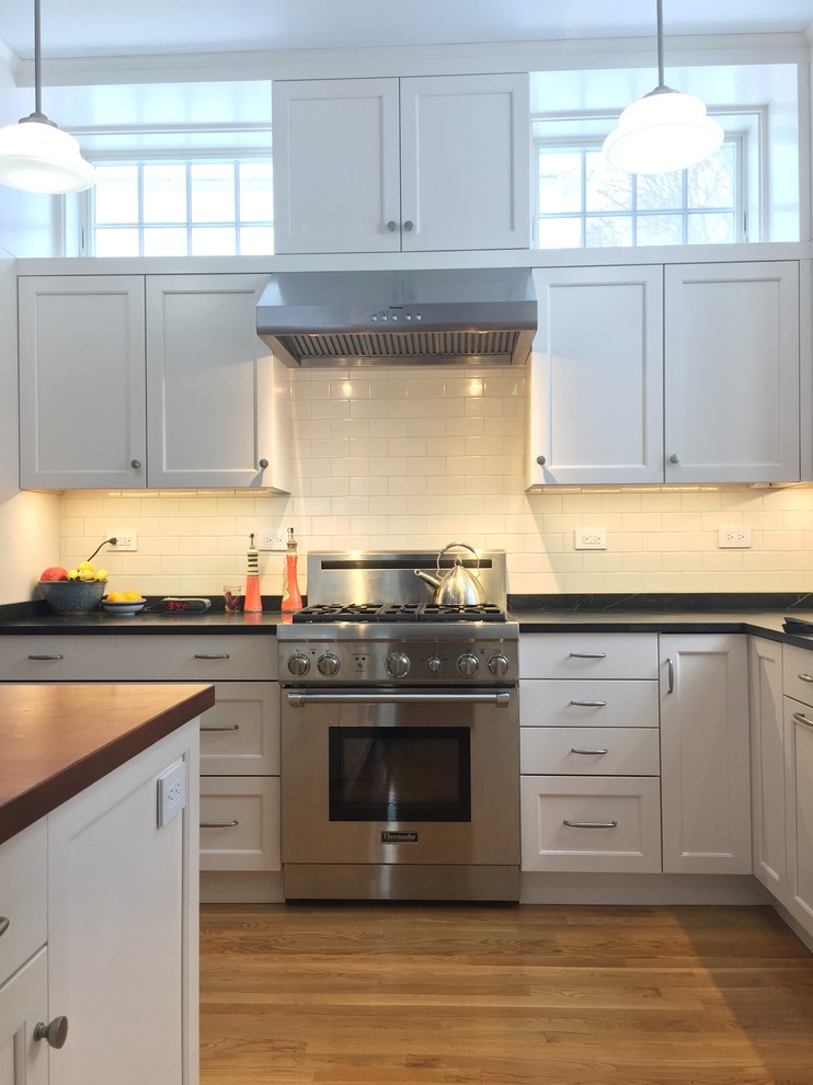 Idéer för att renovera ett mellanstort vintage grå grått kök, med en undermonterad diskho, skåp i shakerstil, vita skåp, bänkskiva i täljsten, vitt stänkskydd, stänkskydd i keramik, rostfria vitvaror, mellanmörkt trägolv, en köksö och brunt golv