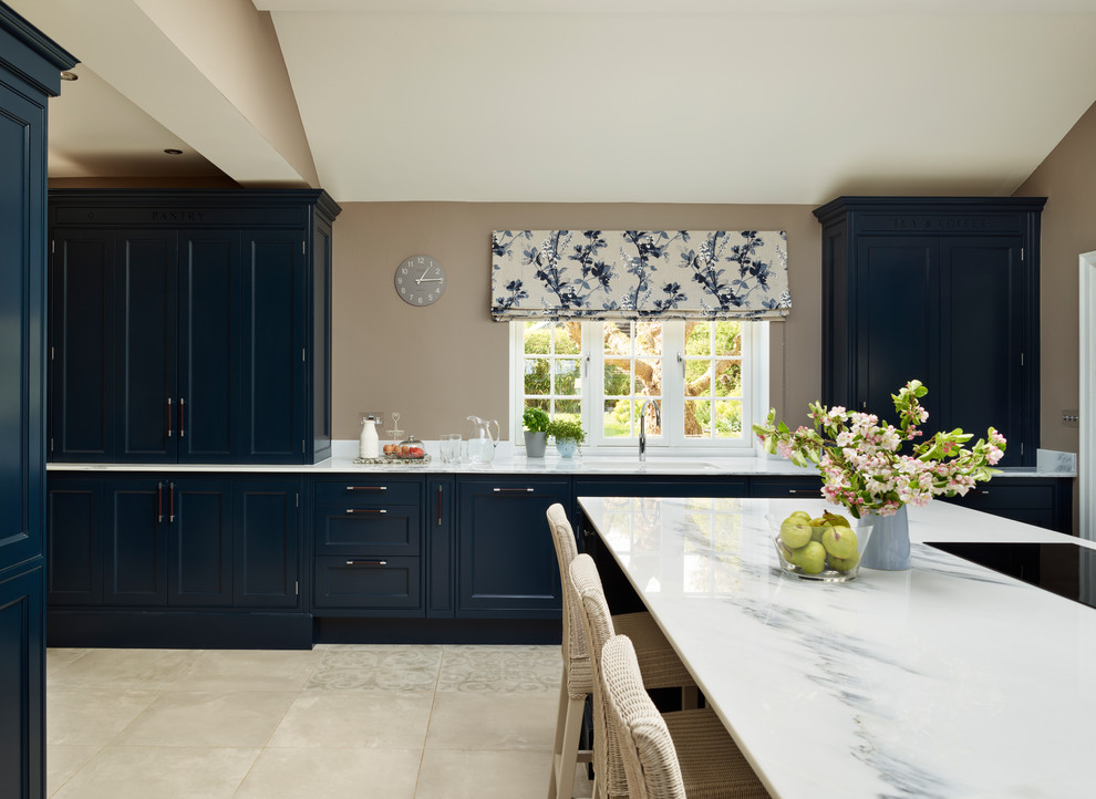 Diseño de cocina clásica grande con armarios con rebordes decorativos, puertas de armario azules, encimera de mármol, electrodomésticos blancos y una isla