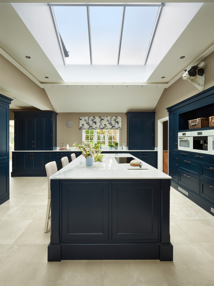 Photo of a large classic kitchen in Essex with beaded cabinets, blue cabinets, marble worktops, white appliances and an island.