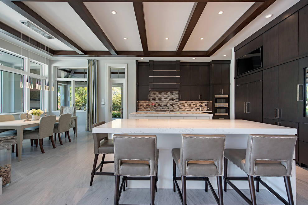 Inspiration for a transitional l-shaped gray floor eat-in kitchen remodel in Miami with flat-panel cabinets, dark wood cabinets, multicolored backsplash, matchstick tile backsplash, paneled appliances, two islands and white countertops