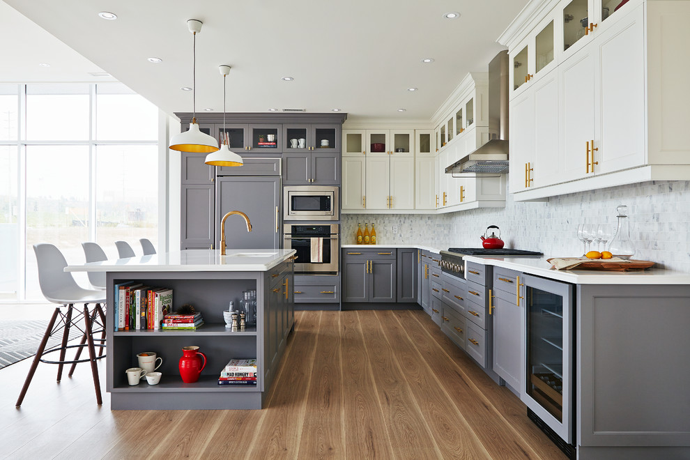 Example of a transitional l-shaped kitchen design in Toronto with gray cabinets, an island, white backsplash and stone tile backsplash