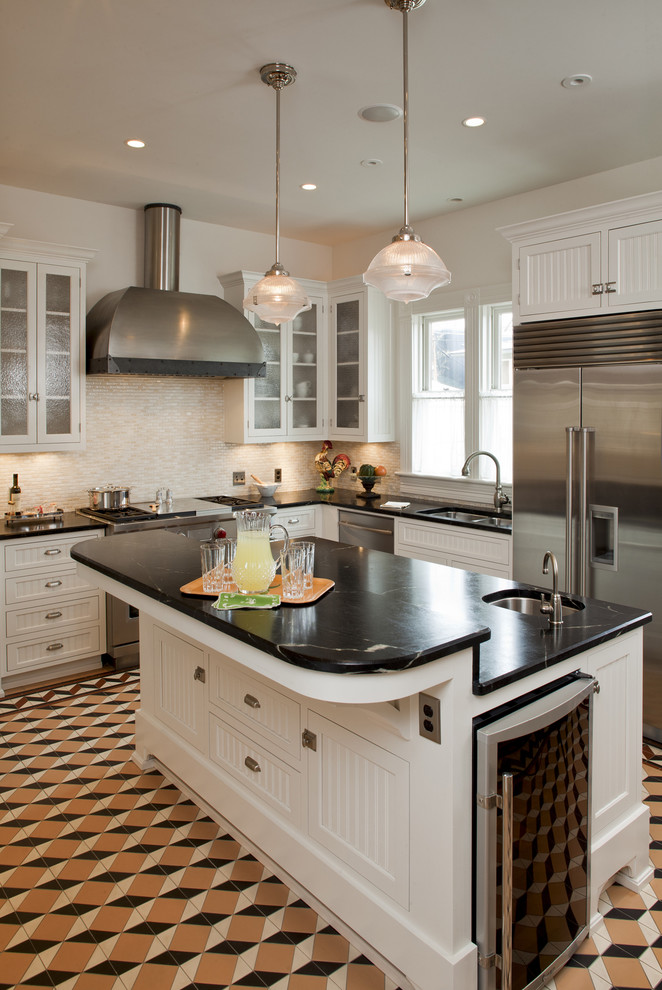 Elegant kitchen photo in Austin with glass-front cabinets and stainless steel appliances