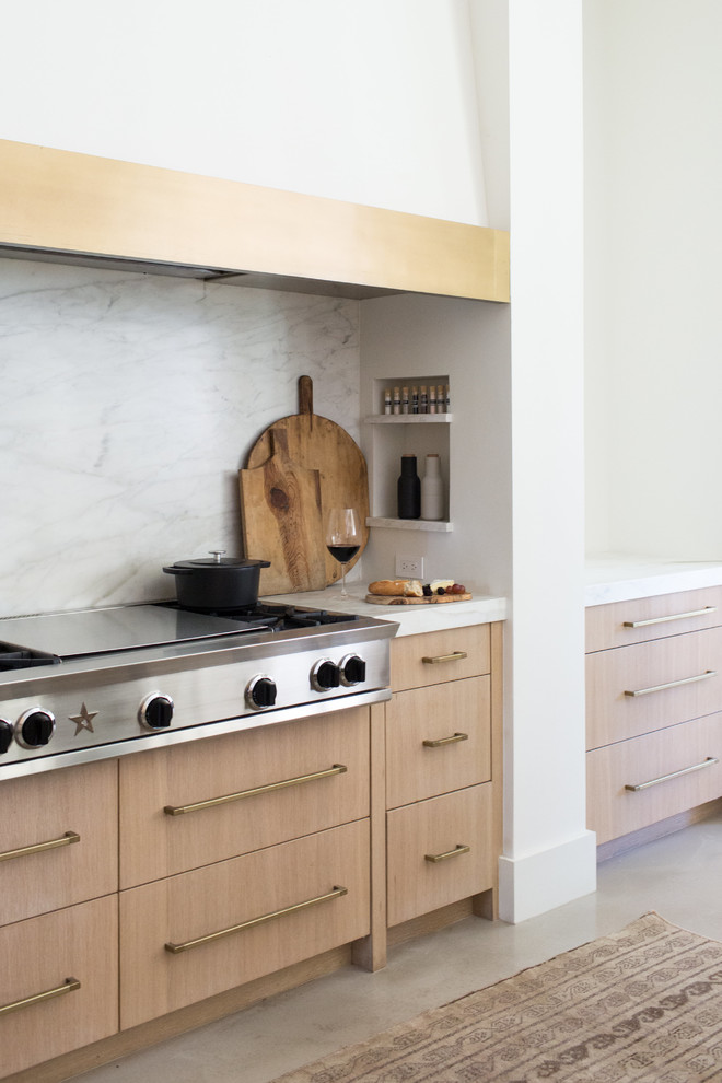 Idéer för stora funkis vitt u-kök, med en enkel diskho, släta luckor, skåp i ljust trä, marmorbänkskiva, vitt stänkskydd, stänkskydd i sten, integrerade vitvaror, betonggolv, en köksö och grått golv