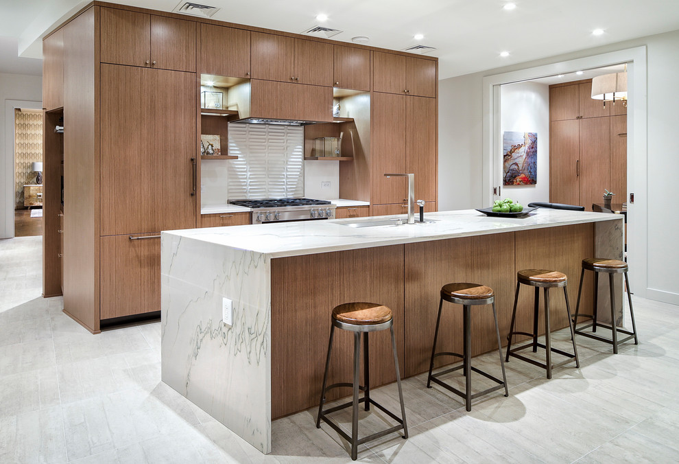 Foto på ett mellanstort funkis vit kök, med en undermonterad diskho, släta luckor, skåp i mellenmörkt trä, integrerade vitvaror, en köksö, grått golv, marmorbänkskiva, vitt stänkskydd, stänkskydd i porslinskakel och klinkergolv i porslin