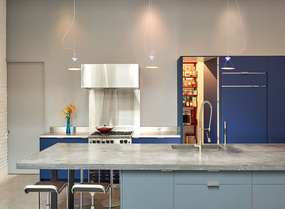 Exemple d'une cuisine encastrable industrielle avec un évier 1 bac, un placard à porte plane, des portes de placard bleues, un plan de travail en inox, une crédence métallisée, sol en béton ciré, îlot et un sol gris.