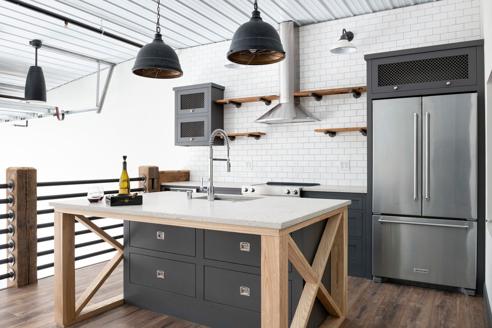 Urban kitchen/diner in Minneapolis with open cabinets, medium wood cabinets, white splashback, stainless steel appliances, an island, brown floors and yellow worktops.