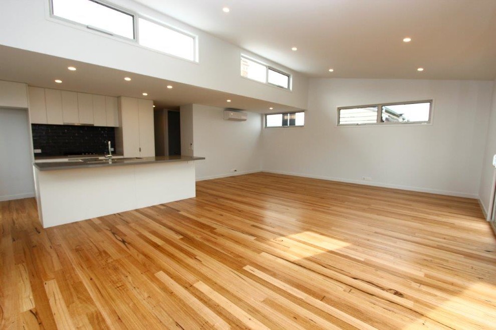 Example of a mid-sized minimalist galley light wood floor eat-in kitchen design in Melbourne with a double-bowl sink, open cabinets, white cabinets, quartz countertops, gray backsplash, ceramic backsplash, stainless steel appliances and an island