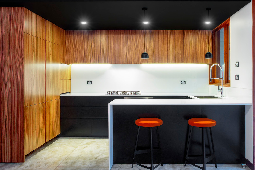 Foto de cocina contemporánea pequeña con fregadero bajoencimera, encimera de cuarzo compacto, salpicadero blanco, salpicadero de vidrio templado, electrodomésticos con paneles y suelo de cemento