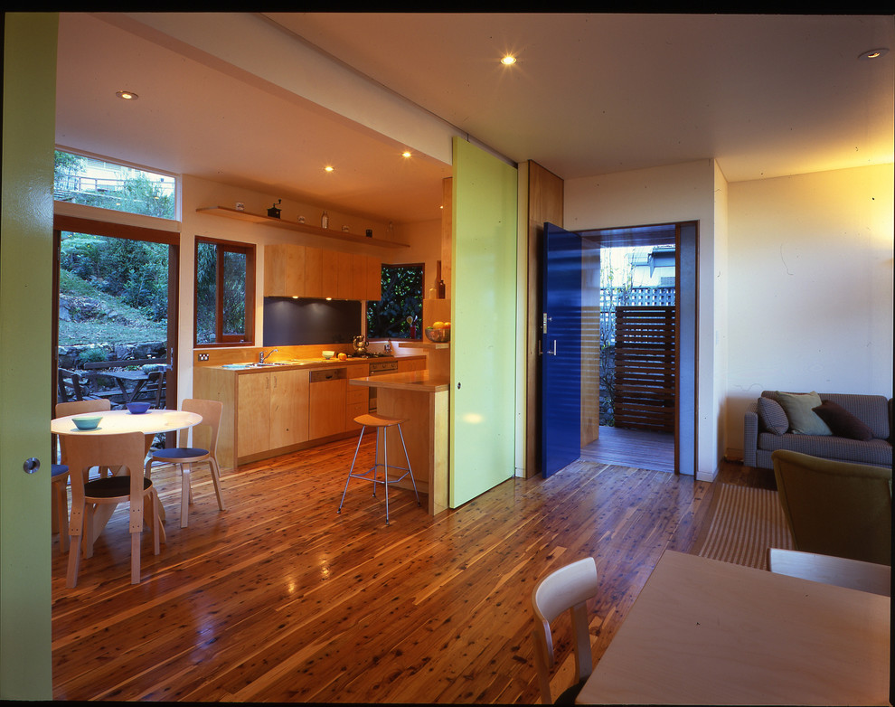 Diseño de cocina costera con armarios con paneles lisos, puertas de armario de madera clara y encimera de madera