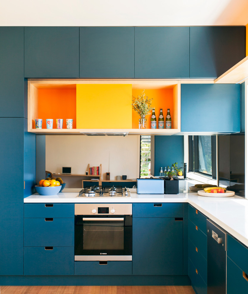 シドニーにあるコンテンポラリースタイルのおしゃれなL型キッチン (フラットパネル扉のキャビネット、青いキャビネット、シルバーの調理設備、無垢フローリング) の写真