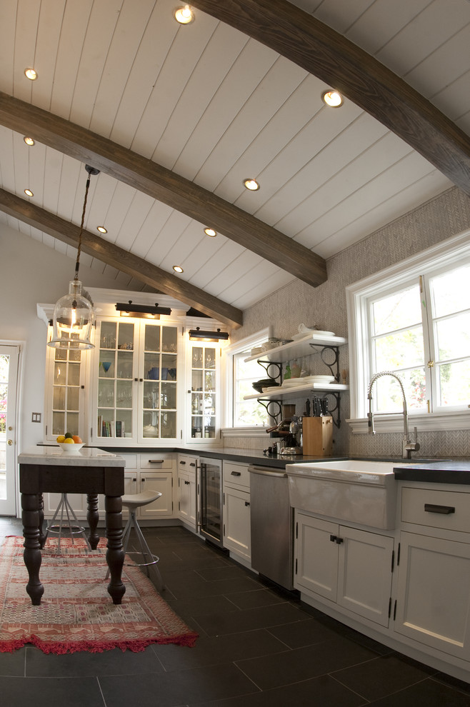 Example of a mountain style kitchen design in Los Angeles with glass-front cabinets, stainless steel appliances, a farmhouse sink and white cabinets