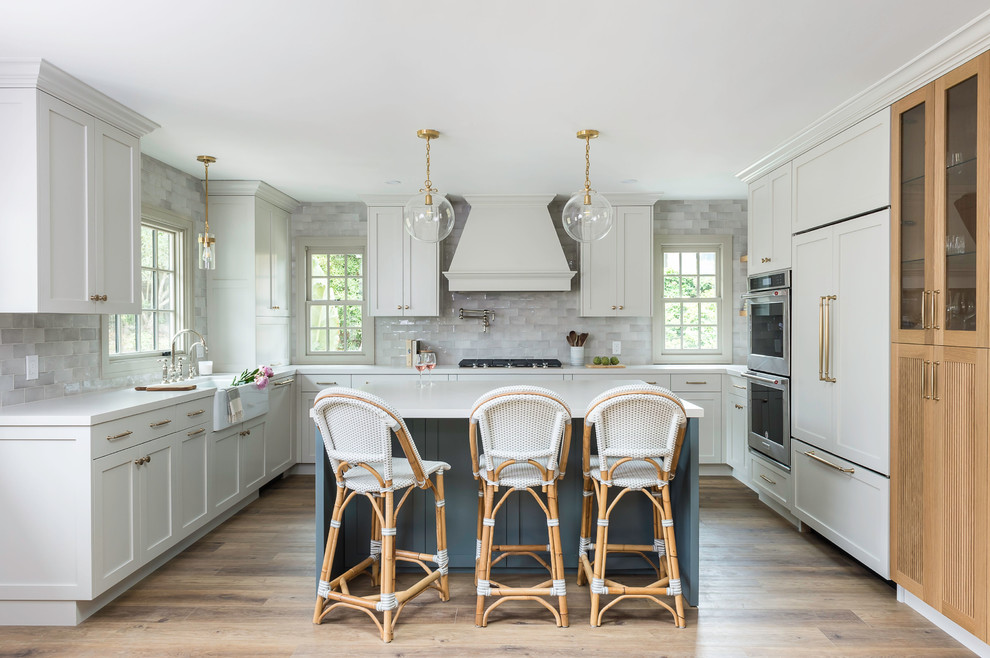 Esempio di una cucina classica con lavello stile country, ante in stile shaker, ante grigie, paraspruzzi grigio, elettrodomestici in acciaio inossidabile, pavimento in legno massello medio, pavimento marrone e top bianco