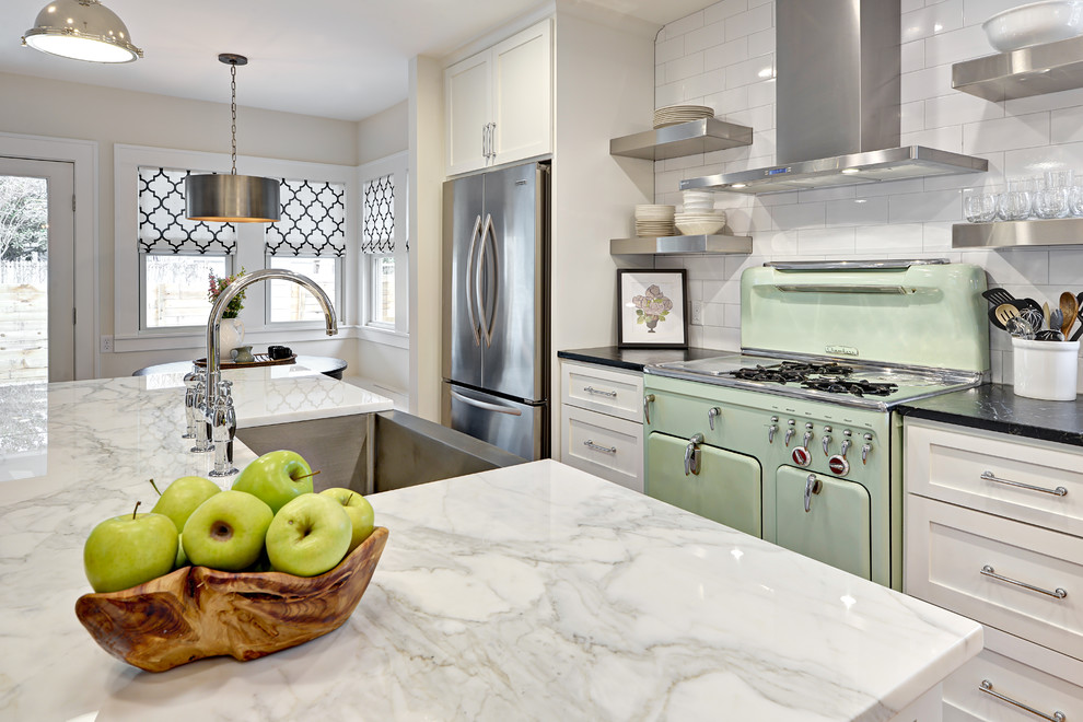 Classic galley kitchen/diner in Austin with a belfast sink, shaker cabinets, white cabinets, marble worktops, white splashback, metro tiled splashback, stainless steel appliances and an island.