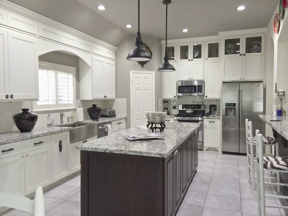 Eat-in kitchen - cottage ceramic tile and gray floor eat-in kitchen idea in Houston with an island, granite countertops, a farmhouse sink, stainless steel appliances, subway tile backsplash, white backsplash and white cabinets