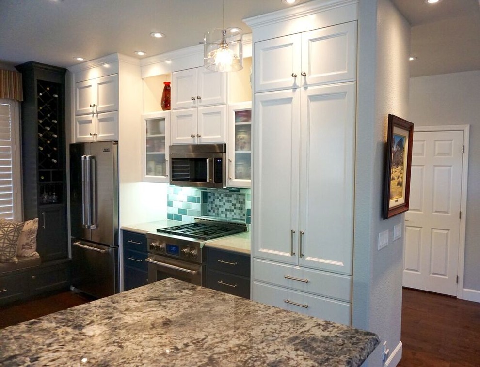 Mid-sized transitional medium tone wood floor and brown floor kitchen photo in San Luis Obispo with recessed-panel cabinets, white cabinets, marble countertops, green backsplash, subway tile backsplash, stainless steel appliances and an island