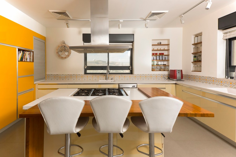 テルアビブにあるコンテンポラリースタイルのおしゃれなアイランドキッチン (シングルシンク、フラットパネル扉のキャビネット、オレンジのキャビネット、マルチカラーのキッチンパネル) の写真