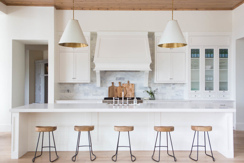 Zweizeilige Klassische Küche mit Glasfronten, weißen Schränken, Küchenrückwand in Weiß, hellem Holzboden, Kücheninsel, Landhausspüle und Küchengeräten aus Edelstahl in Salt Lake City