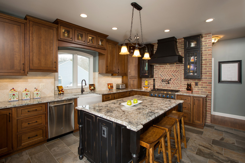Inredning av ett rustikt mellanstort kök, med en rustik diskho, luckor med infälld panel, skåp i slitet trä, granitbänkskiva, stänkskydd i tegel, rostfria vitvaror, skiffergolv och en köksö