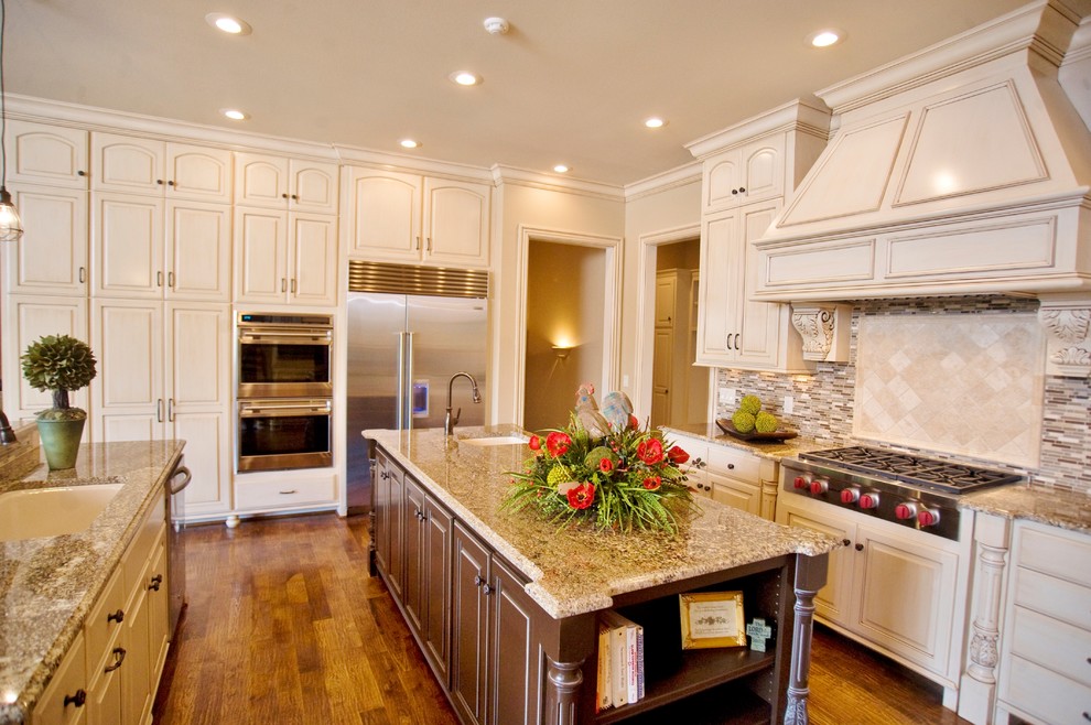 Example of a classic u-shaped enclosed kitchen design in Other with an undermount sink, recessed-panel cabinets, white cabinets, granite countertops, multicolored backsplash, mosaic tile backsplash and stainless steel appliances