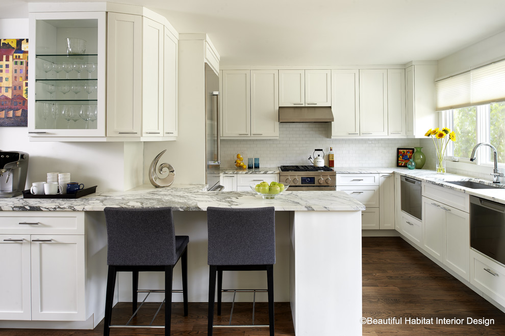 Example of a small minimalist u-shaped dark wood floor eat-in kitchen design in Denver with a single-bowl sink, shaker cabinets, white cabinets, marble countertops, white backsplash, ceramic backsplash and stainless steel appliances