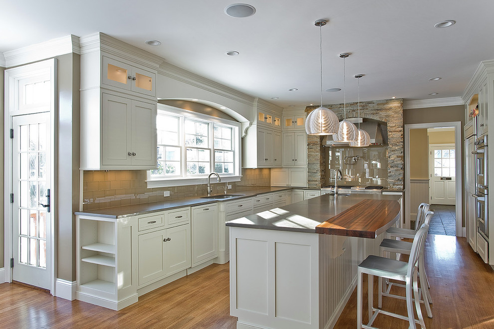 Foto di una cucina ad U country con ante in stile shaker, top in legno, paraspruzzi beige, ante grigie, elettrodomestici in acciaio inossidabile e paraspruzzi con piastrelle di vetro