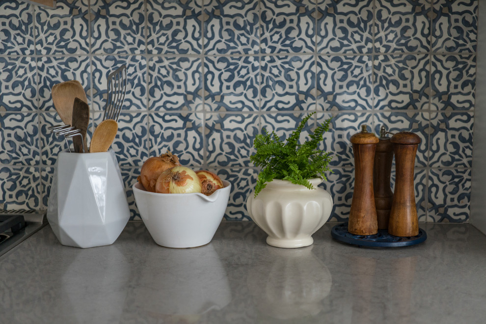 Bild på ett avskilt funkis u-kök, med en rustik diskho, skåp i shakerstil, vita skåp, rostfria vitvaror, en köksö, grått golv, bänkskiva i kvarts, flerfärgad stänkskydd och stänkskydd i keramik