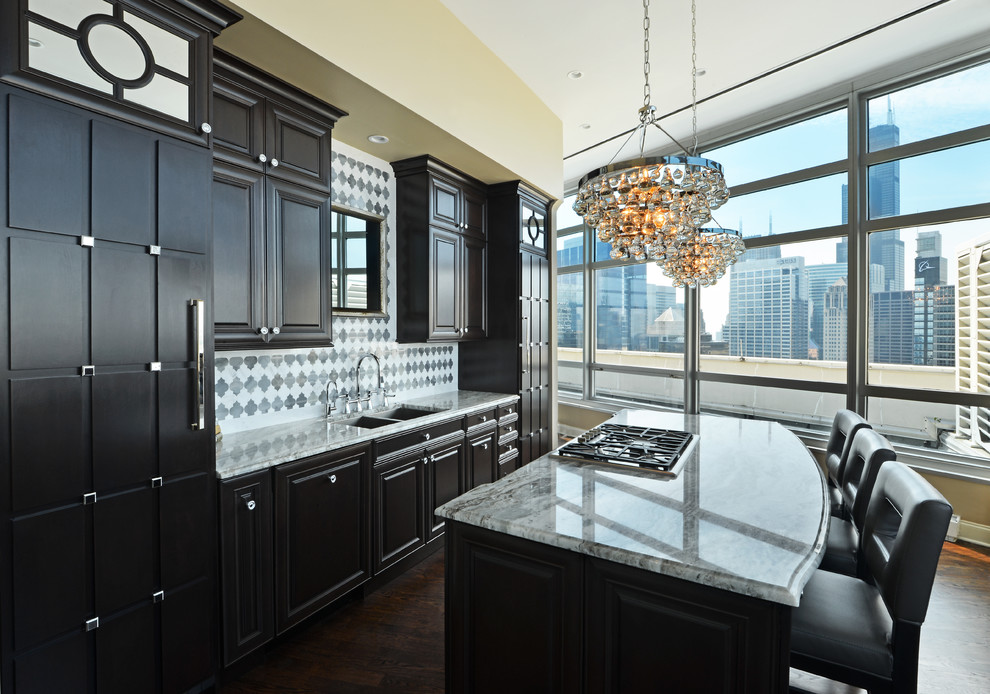 Elegant single-wall eat-in kitchen photo in Chicago with a drop-in sink, raised-panel cabinets, dark wood cabinets, marble countertops, white backsplash and stainless steel appliances