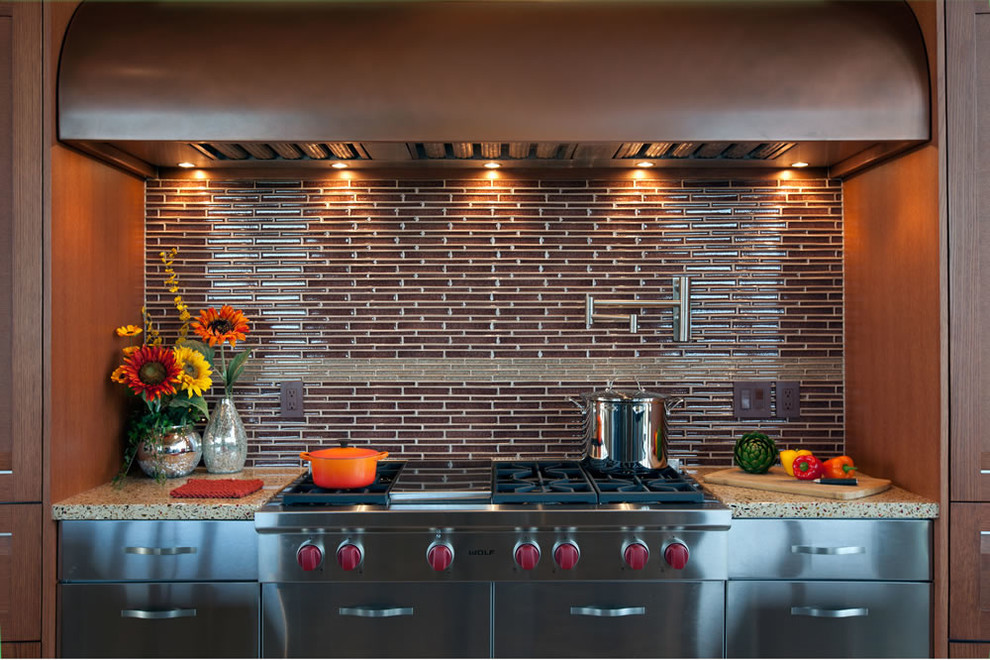 Foto på ett stort funkis kök, med rostfria vitvaror, luckor med infälld panel, skåp i rostfritt stål, brunt stänkskydd, stänkskydd i glaskakel, flera köksöar och bänkskiva i terrazo