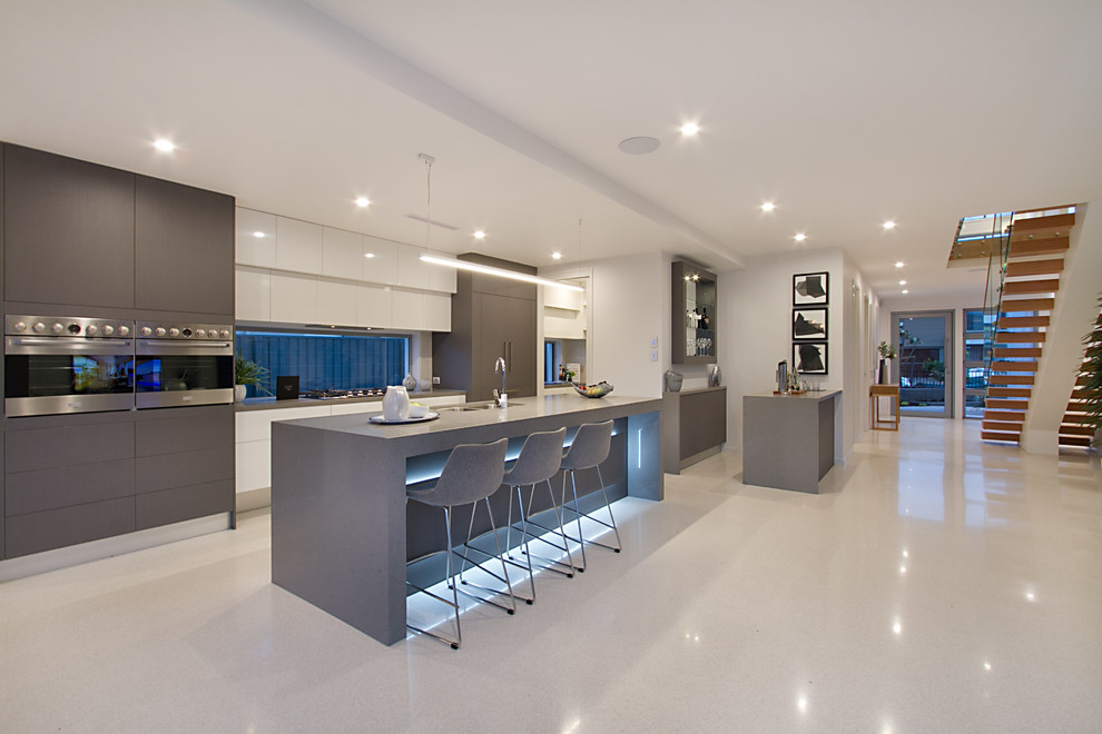 Contemporary galley kitchen in Gold Coast - Tweed with a submerged sink, flat-panel cabinets, grey cabinets, stainless steel appliances, an island, grey floors and grey worktops.