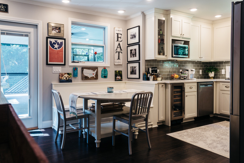 Eat-in kitchen - small craftsman u-shaped dark wood floor eat-in kitchen idea in Nashville with a farmhouse sink, shaker cabinets, white cabinets, quartz countertops, gray backsplash, glass tile backsplash and stainless steel appliances