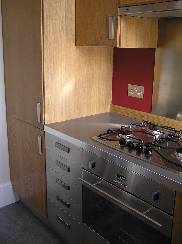 Esempio di una cucina contemporanea con ante lisce, ante in legno chiaro, top in acciaio inossidabile e elettrodomestici in acciaio inossidabile