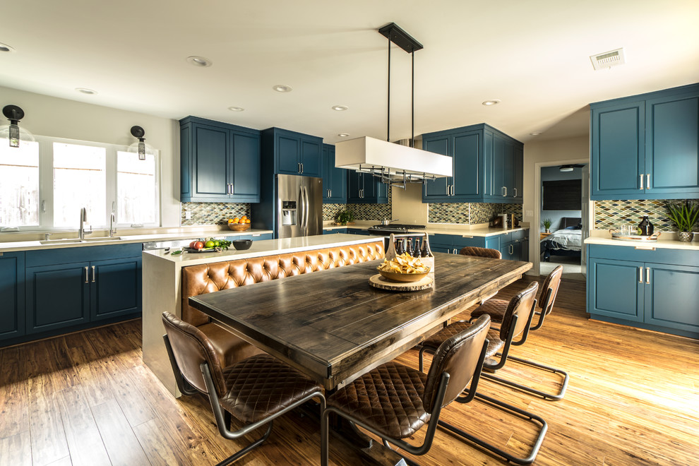 Exempel på ett mellanstort klassiskt vit vitt kök, med en undermonterad diskho, luckor med upphöjd panel, blå skåp, bänkskiva i kvarts, blått stänkskydd, stänkskydd i glaskakel, rostfria vitvaror, mellanmörkt trägolv, en köksö och brunt golv