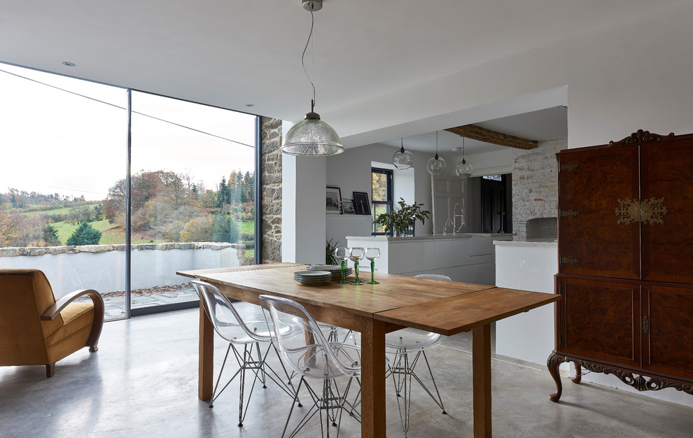 Esempio di una sala da pranzo aperta verso il soggiorno scandinava di medie dimensioni con pavimento in cemento e pavimento grigio