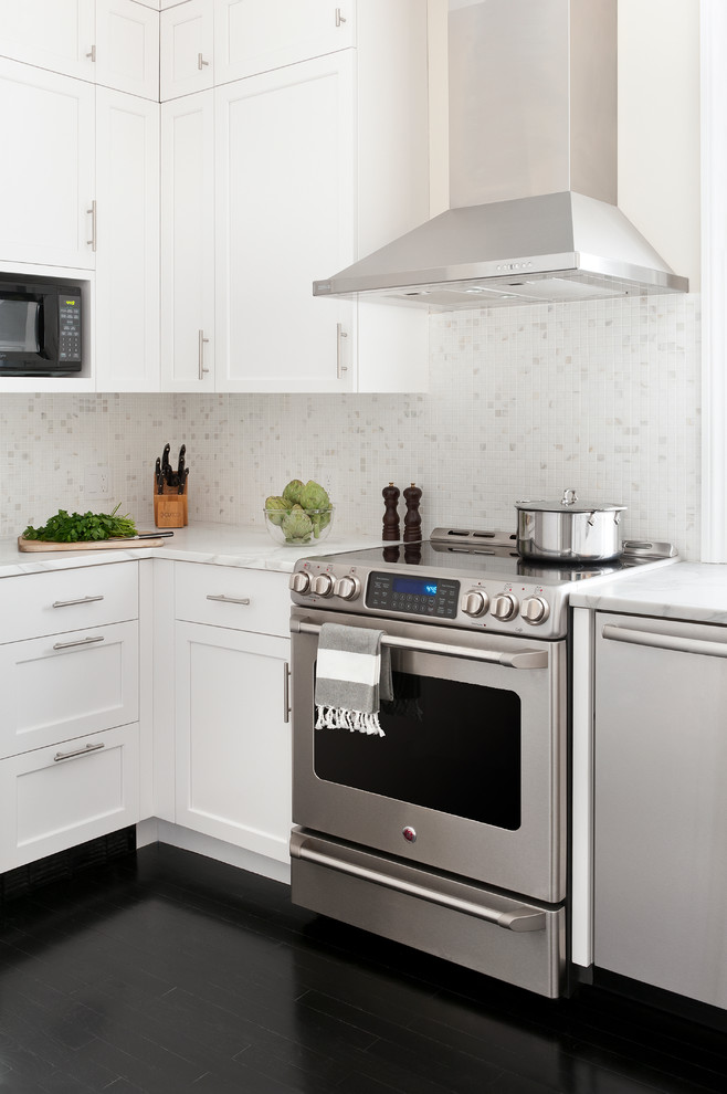 Example of a transitional black floor kitchen design in Boston with recessed-panel cabinets, white cabinets, white backsplash, stainless steel appliances and marble backsplash