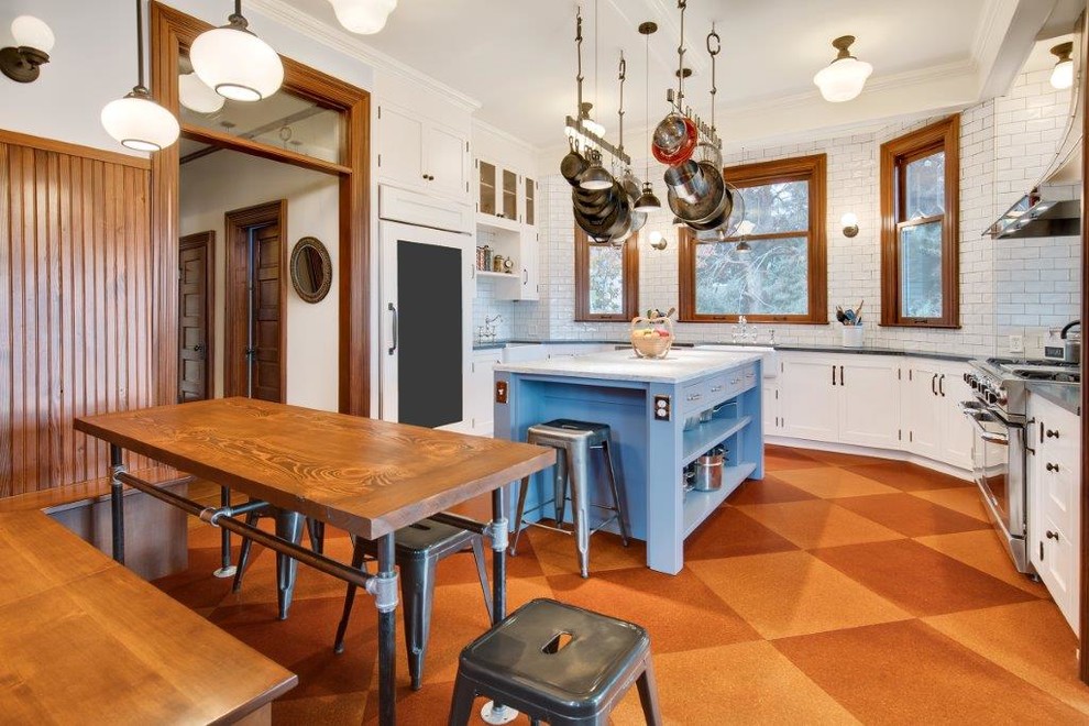 Foto på ett mellanstort lantligt kök, med en rustik diskho, skåp i shakerstil, vita skåp, bänkskiva i kvarts, vitt stänkskydd, stänkskydd i tunnelbanekakel, vita vitvaror, korkgolv, en köksö och brunt golv