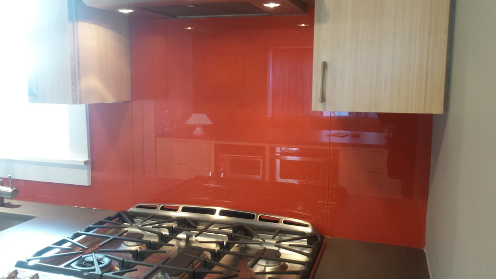 Moderne Küche mit flächenbündigen Schrankfronten, hellen Holzschränken, Küchenrückwand in Orange und Glasrückwand in Washington, D.C.