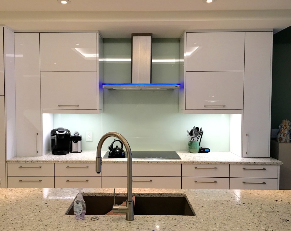 Immagine di una grande cucina contemporanea con lavello da incasso, ante lisce, ante bianche, top in marmo, paraspruzzi verde, paraspruzzi con lastra di vetro e elettrodomestici in acciaio inossidabile
