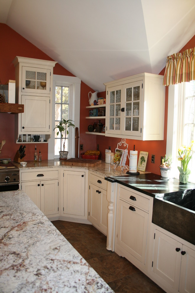 This is an example of a medium sized country u-shaped kitchen/diner in New York with a belfast sink, flat-panel cabinets, white cabinets, granite worktops, stainless steel appliances, ceramic flooring and an island.