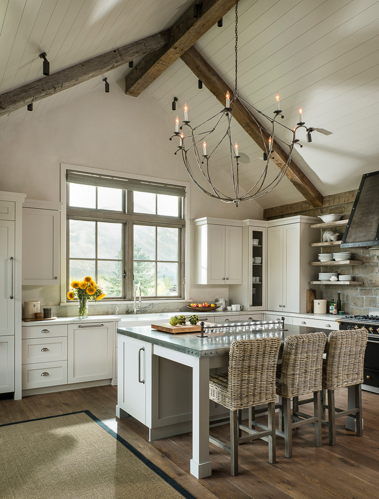 Kitchen - rustic l-shaped dark wood floor kitchen idea in Other with a farmhouse sink, shaker cabinets, white cabinets, black appliances and an island
