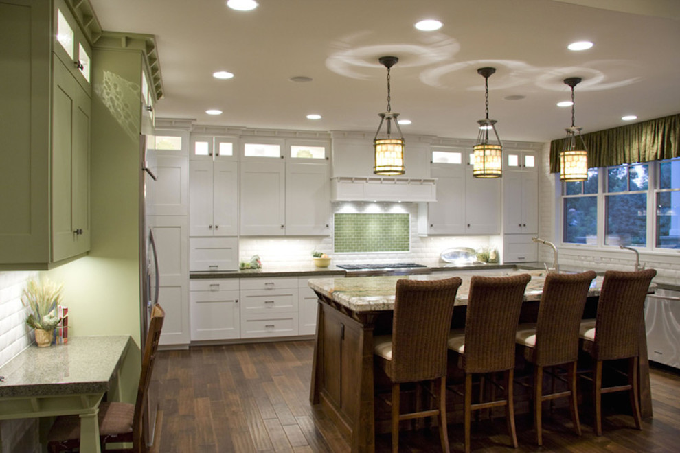 Exempel på ett mellanstort klassiskt kök, med en dubbel diskho, luckor med infälld panel, vita skåp, bänkskiva i kvarts, vitt stänkskydd, stänkskydd i porslinskakel, rostfria vitvaror, mörkt trägolv, en köksö och brunt golv