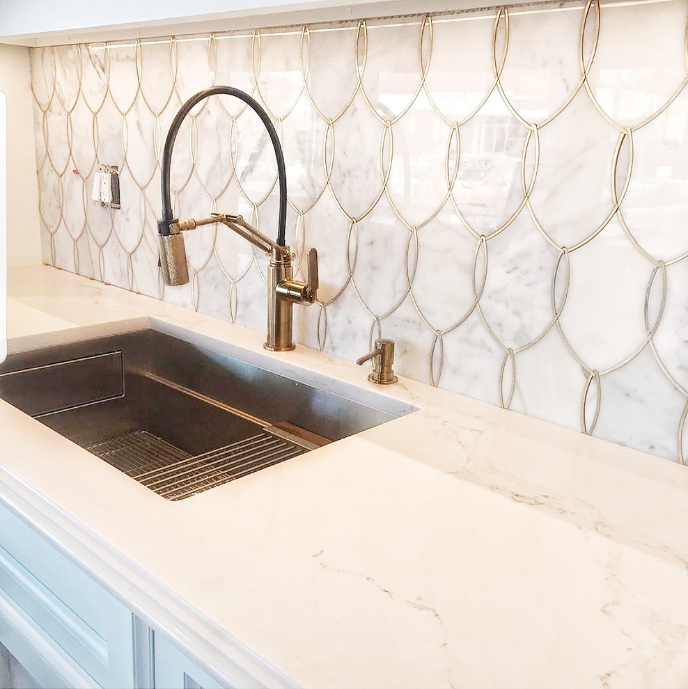 Foto på ett litet eklektiskt vit linjärt kök och matrum, med en undermonterad diskho, luckor med upphöjd panel, vita skåp, marmorbänkskiva, vitt stänkskydd, stänkskydd i marmor, rostfria vitvaror, mörkt trägolv, en köksö och brunt golv