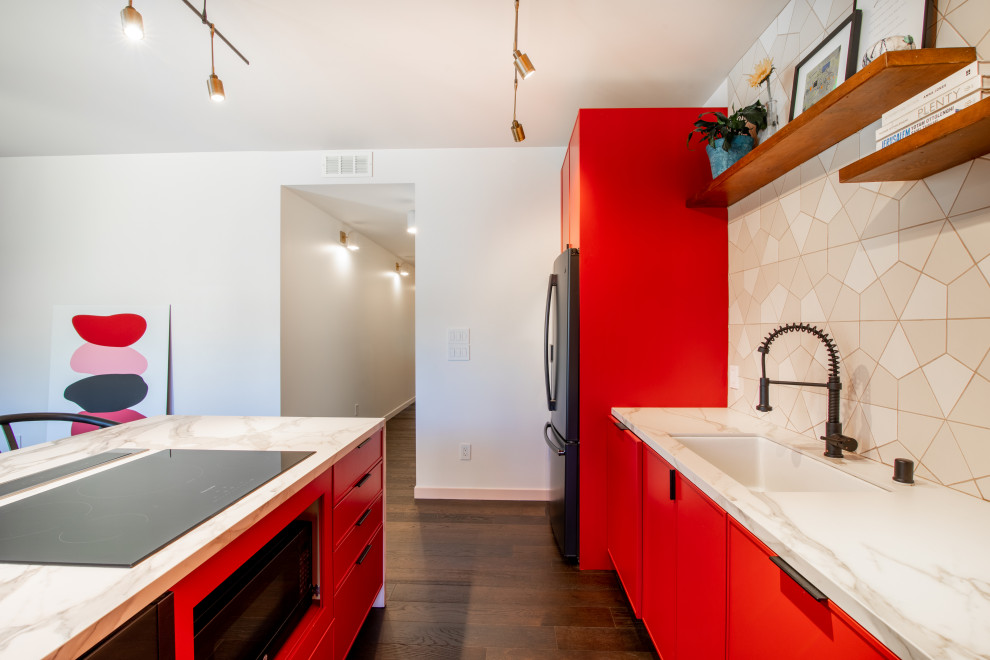 Cette image montre une grande cuisine américaine linéaire minimaliste avec des portes de placard rouges, plan de travail en marbre, une crédence blanche, une crédence en céramique, un sol en bois brun, îlot, un sol marron et un plan de travail blanc.
