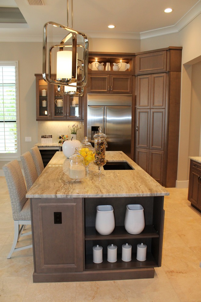 Example of a large classic galley travertine floor and beige floor eat-in kitchen design in Tampa with an undermount sink, recessed-panel cabinets, medium tone wood cabinets, granite countertops, gray backsplash, ceramic backsplash, stainless steel appliances and an island