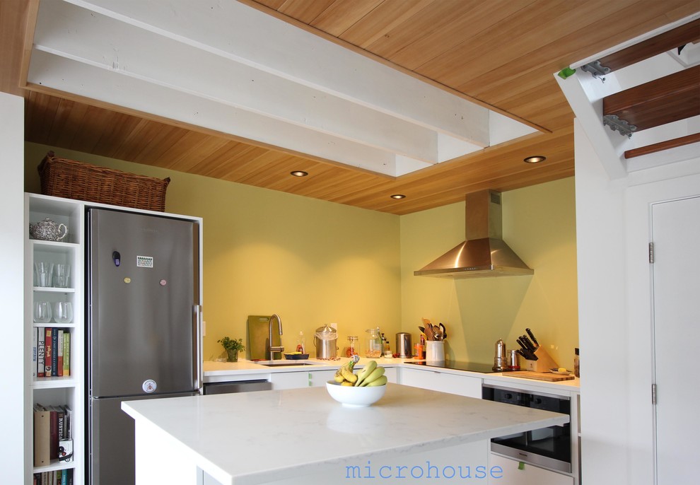 Esempio di una piccola cucina design con lavello sottopiano, ante lisce, ante bianche, top in quarzo composito, elettrodomestici in acciaio inossidabile e pavimento in cemento